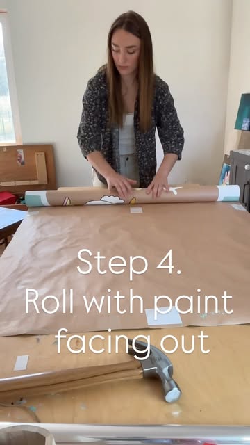 Ella rolling a finished banner with the paint facing out